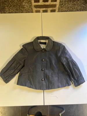 Grå prickig peacoat/jacka från expresso  - Snygg grå jacka från expresso med små vita prickar, stora knappar framtill och bred rund krage. Jackan har trekvartsärm med resår vid ärmslut och är tillverkad i ett mjukt bomullsmaterial. Perfekt för dig som gillar retrostil! Storlek 42 men passar som en xs-s. Ca. 45cm hög, 35cm från axelsöm till axelsöm. Hör gärna av er vid frågor! 💕