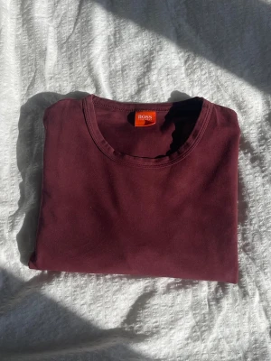 Vinröd t-shirt från Hugo Boss - Snygg vinröd t-shirt från Hugo Boss med klassisk rund halsringning. 