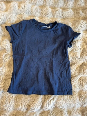 Mörkblå t-shirt från Gina Tricot - En enkel och stilren mörkblå t-shirt från Gina Tricot. T-shirten har rund halsringning och korta ärmar.💖