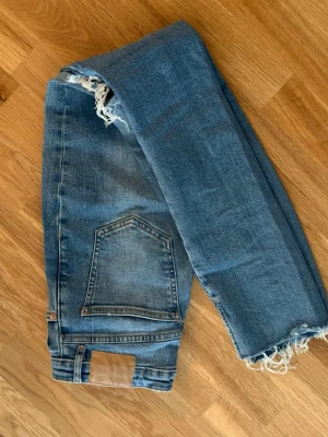 Blå slitna jeans med hål på knäna - Jeans från Zara 