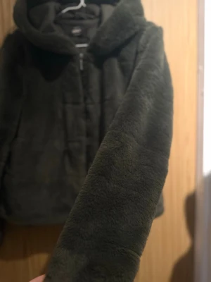 Tunn  fuskpälsjacka  - fluffig mörkgrön fuskpälsjacka ganska tunn