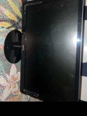 BenQ svart datorskärm LED - Säljer en svart BenQ LED-datorskärm med rund fot och knappar på framsidan. Skärmen har en stilren design med tunn ram och passar perfekt till datorbordet. Materialet är plast och ytan är blank.