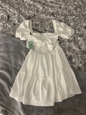 Studentklänning - Vit söt klänning från Gina Tricot som man knyter i ryggen. Storlek S. Helt ny med prislapp. Om du hittar något mer du gillar kan vi diskutera ett bra paketpris!