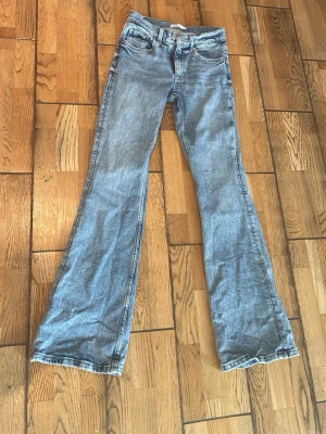 Blå bootcut jeans från Gina tricot  - Säljer ett par ljusblå bootcut jeans. Jeansen har en snygg tvätt i denim. de är i fint skick endast använda fåtal gånger. Jeansen är i storlek 34 från Gina tricot. 