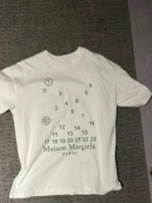 Maison Margiela vit t-shirt med tryck - Vit t-shirt från Maison Margiela med ikoniskt siffertryck.                                             För stor för mig men passar nog M.          Aldrig använt så den är helt ny.