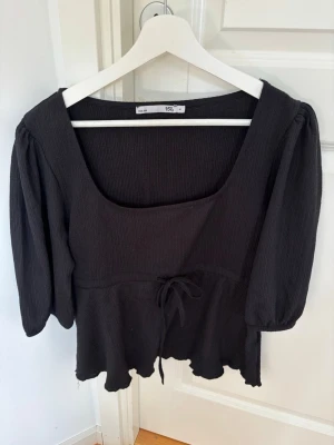 Svart topp med knyt och volang - Svart topp perfekt till sommarn