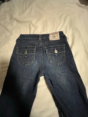 True Religion mörkblå jeans - Säljer ett par mörkblå jeans från True Religion. Storlek W23. Inte använda mycket. Är öppen om någon vill byta mot ett par ljusblåa joey W23