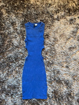 Blå ribbad cut-out klänning - Trendig blå ribbad klänning med cut-out detaljer i midjan och ärmlös design från H&M DIVIDED. Klänningen är kroppsnära och har en rund halsringning. Använt 1 gång. Strlk XS. ALLA PRISER KAN DISKUTERAS