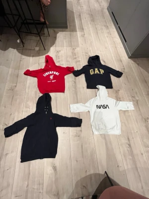 Mix av hoodies från kända märken - Säljer ett gäng snygga hoodies från märken som Liverpool, GAP, NASA, Adidas, FILA, Vans och Peak Performance. Färgerna är blandade: röd, svart, vit, grå, blå och beige. Alla har huva och tryck eller brodyr framtill. Perfekt för dig som gillar streetwear och sportiga vibes.