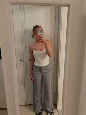 Gråa vida kostymbyxor från Gina  - Säljer ett par gråa kostymbyxor med rak och vid passform i storlek 32(innerbenslängd 74cm och hela 95) De har resår i midjan och har mjukt material