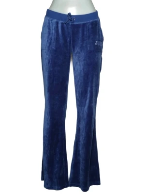 Blå lågmidjade vintage Juicy Couture - Mjukisbyxor i pipeline-blå velour vintage från Juicy med bred bootcut. Framfickor och ikonisk krona i strass force på bakfickan. Perfekta för chill eller när du vill ha den där mjuuuka känslan.