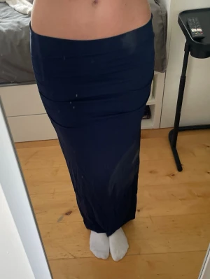 Mörkblå lång tight kjol - Säljer en mörkblå långkjol med tight passform och hög midja. Kjolen är figurnära och har en slät, enkel design utan synliga detaljer. Perfekt för dig som vill ha en kjol som sitter snyggt längs kroppen.🥰