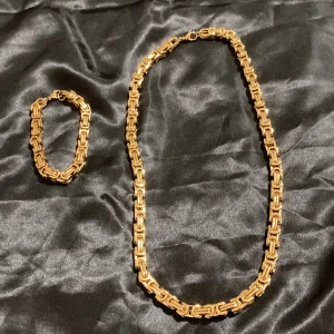 Halsband & armband 18K dubbel pläterad  PVD - Perfekt Nu till sommaren. Halsband som väger 150 g. Längden är 60 cm och bredden 8 mm. Halsbandet är tillverkat av äkta 18K guld och doppat i PVD för extra hållbarhet och glans cirka. Till halsbandet finns även ett matchande armband 60 g 8mm bredd. Kvaliteten är mycket hög, bättre finns inte i denna klass