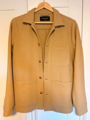A days march overshirt - Stilren overshirt/jacka från A Day's March i tunn ull, perfekt för kyliga sommarkvallar. Schysst look och fin struktur i tyget. Perfekt för layering eller som lättare jacka. Skulle saga True to size Utmärkt skick utöver att lappen i nacken håller på att lossna, men absolut inget som märks eller syns vid anvandning. Skriv vid frågor!