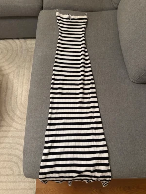 Klänning - Snygg långklänning med svarta och vita ränder. Det är en bandeu klänning från bershka. 