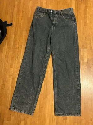 Svarta loose fit jeans med raka ben från Zara - Säljer ett par svarta jeans med loose fit och raka ben. Jeansen har klassisk femficksdesign, bälteshällor och knappgylf. Perfekta för en avslappnad och trendig stil. Materialet är denim i bomull.