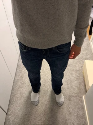 Levis jeans  - Säljer ett par mörkblå slim fit jeans med klassisk femficksdesign och snygga slitningar. Jeansen har normal midja och raka ben, perfekta för en avslappnad men stilren look. Materialet är mjukt och stretchigt för extra komfort.