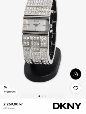 Diamanter silverklocka från DKNY, ÄKTA klocka! - Snygg och glittrig klocka från DKNY i silverfärgat metallarmband med rektangulär urtavla. Armbandet är täckt av gnistrande stenar i rutmönster som ger en lyxig känsla. Perfekt accessoar för att sticka ut och addera extra bling till din stil. Nypris ca 2300-3400kr, helt äkta, endast använd 1-2 ggr. Inga fel eller skader/repor finns INTE! BLING BLING ✨💯 FÖRST TILL KVARN!
