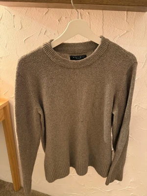 Beige stickad tröja från Amisu - En stilren beige stickad tröja från Amisu med rund halsringning och ribbade muddar vid ärmslut och nederkant. Perfekt för lager-på-lager och enkel att matcha med olika outfits. Mjuk och bekväm känsla.