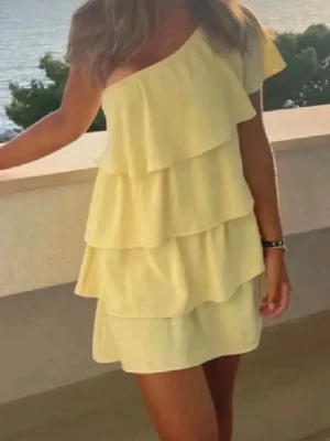  Ny Gul offshoulder volangklänning från Zara med prislapp  - Superfin gul kortklänning med flera volanger och offshoulder-design. Perfekt för varma dagar och somriga vibes. Klänningen har en lös passform och är tillverkad i ett lätt material som känns skönt mot huden.