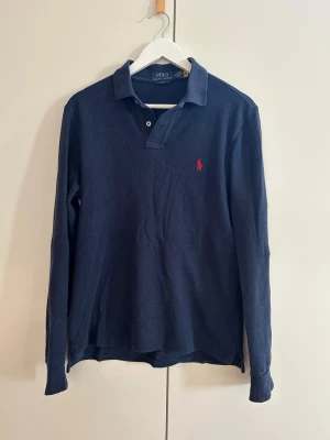 Ralph lauren långsrmad pike - Säljer denna Ralph Lauren långarmade piké i storlek M, perfekt för sommaren. Skick 9/10, sparsamt använd. Säljer då den är för liten för mig. Passar bäst om du är 180-185 cm lång. Nypris 1500kr, mitt pris 599kr Skriv vid frågor och funderingar!