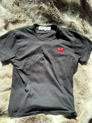 Comme des Garcons T-shirt  - Svart tshirt i storlek S och i riktigt bra skick bara använd fåtal gånger. Mitt pris är 350kr ny pris runt 1000kr, bara höra av dig vid minsta fundering.👋
