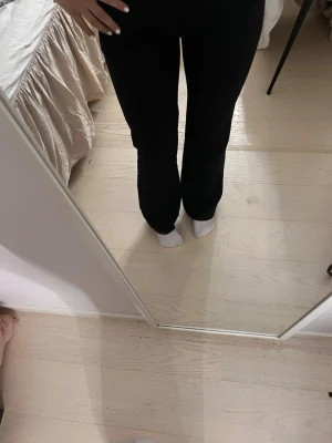 Svarta raka kostymbyxor - Säljer ett par svarta kostymbyxor med rak passform och normal midja.  har klassisk femficksdesign och bälteshällor. Perfekta för en clean och stilren look.