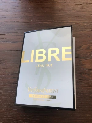 Yves Saint Laurent Libre L'Eau Nue. 1,2 ml - Snygg parfym från Yves Saint Laurent, Libre L'Eau Nue. Förpackningen är vit med guldiga detaljer och svart ram. Parfymen kommer i sprayform och har en modern, elegant design som känns lyxig och trendig.