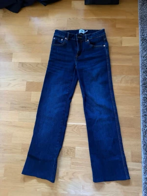 Mörkblå jeans från lager 157 - Snygga mörkblå jeans med raka ben och klassiska kontrastsömmar. Jeansen har två bakfickor med lock och knapp samt en patch med märket Lager 157. Perfekt för dig som gillar en enkel och tidlös stil.