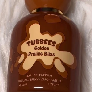 Tubbees Golden Praline Bliss parfym - Säljer Tubees Golfen Pralinen Bliss Eau de Parfum 50 ml som endast är använd en gång när jag provade den. Doften är en mjuk och söt gourmanddoft med inslag som påminner om praliner och vanilj, perfekt för dig som gillar varma, feminina och lite mysiga parfymer som fungerar både till vardag och kväll. Flaskan är i fint skick och den är i princip helt ny då den bara testats en gång. 
