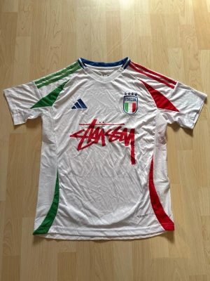 Italien x Stüssy Borta Kit Special Edition  - Stilren fotbollströja i helt nytt skick. Tröjan är inte använd en endaste sekund. Italien tröjan är kombinerad med det exklusiva streetwear märket Stüssy.