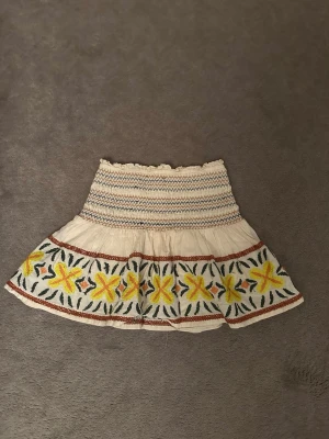 Beige kjol med broderade blommor -  Trendig & supersöt beige kjol med broderade gula blommor och lite andra detaljer. Kjolen är ifrån Zara i storlek 9-10 år. 🩷 