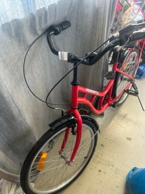 Röd Yosemite cykel med pakethållare - Säljer en röd cykel från Yosemite med klassisk ram, svart sadel och svarta handtag. Cykeln har pakethållare bak, reflexer på hjulen och stänkskärmar i svart. Perfekt för dig som vill ha en enkel och snygg cykel för stan eller skolan. Lite problem med bromsen. Annars är allt annat perfekt 