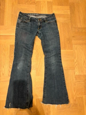 Bullhead lowrise, bootcut jeans - Säljer ett par blå bootcut jeans ifrån bullhead. Jeansen är i fint skick och är lowrise. Storlek XS