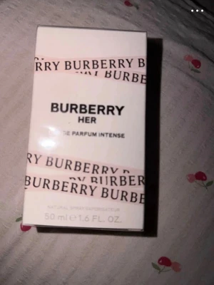 Burberry Her EdP Intense 50ml - Burberry Her Eau de Parfum Intense är en lyxig parfym i en elegant vit kartong med rosa och svarta detaljer. Flaskan rymmer 50 ml och doften är intensiv och feminin, perfekt för dig som vill sticka ut med en modern och sofistikerad signaturdoft.