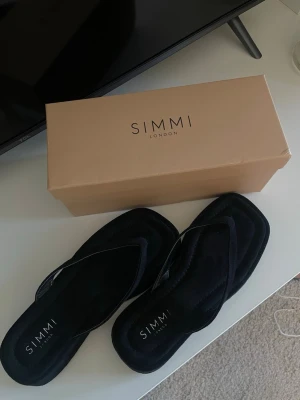 Svarta platåsandaler från Simmi London - Säljer ett par helt nya och oanvända svarta platåsandaler från Simmi London. Stl. 38. Kommer med originalkartong.