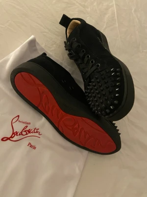 Christian Louboutin i mocka med spikar - Ett par svarta Louboutin sneakers i mocka och spikar. Unisex i storlek 38 med snören. Använda 2 gånger. Påsen är med. Skriv till mig privat om du har några frågor, skriv gärna innan du köper.