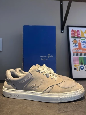 Jacob cohen grå skor  - Säljer ett par Jacob Cohën Dreamer sneakers i grått läder. Stilrena premiumsneakers från italienska Jacob Cohën med präglad J-logga på sidan. Använda men i bra skick med normalt slitage. Väldigt bekväma och passar både till jeans och mer uppklätt.  Nypris runt 7000 kr.  Pris: 1500 kr ✌️Hör gärna av dig om du har några frågor.