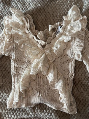 Beige stickad tröja med spetsvolanger - Säljer en långärmad sommar top från Zara. Fin till sommaren och våren. 🌷🌷Den är storlek M men fungerar som S också. Ny utan prislapp!😊