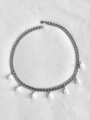 Silverfärgat halsband med pärlor - Ett trendigt silverfärgat halsband med kraftig kedja och sju vita droppformade pärlor som hänger längs kedjan. Perfekt för att ge din outfit en cool och elegant touch. Materialet är rostfritt stål och pärlorna.