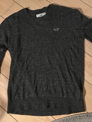 Hollister stickad tröja - Tjena! Säljer denna feta tröjan från Hollister i storlek XS. Modellen på bilden är 172 och väger 55kg, men tröjan kan passa ända upp till 180. Tröjan är i en snygg unik grå färg. Tröjan har inga defekter eller fläckar och är i mycket bra skick!