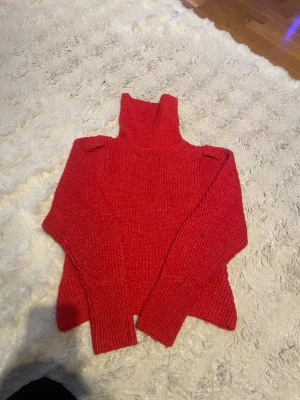 Röd polotröja från Gina Tricot - Säljer en snygg röd stickad polotröja från Gina Tricot. Tröjan har lång ärm, hög polokrage och är gjord i ett mjukt, ribbstickat material. Perfekt för kalla dagar och enkel att styla med jeans eller kjol.