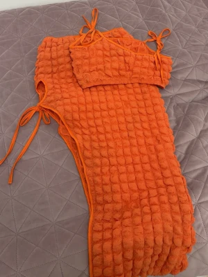 Orange set  - Aldrig använt! Ett tvådelat set med ribbad struktur. Setet består av en topp med tillhörande kjol. Materialet är mjukt och stretchigt, som framhäver kroppens drag. 