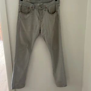 Grå Levis 501 jeans - Säljer ett par klassiska grå Levis 501 jeans i storlek W31 L32. De har en rak passform som är lite smalare längst ner i benen. Har använt jeansen varsamt och därav är de inga direkta slitningar, (skick 8/10). Hör gärna av er vid frågor eller funderingar!