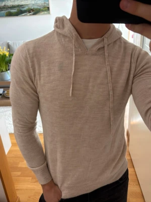 Merinoull hoodie - Beige merinoull hoodie i storlek S, litet hål vid högra armen. Modellen är ca 180, 70kg. Hör av er vid minsta fundering🙌🏽