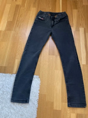 Svarta slim fit jeans från Levi's - Säljer ett par svarta slim fit jeans från Levi's med klassisk femficksdesign och stretchig midja. Jeansen har raka ben och en liten röd Levi's-lapp på fickan fram. Perfekta för dig som gillar en enkel och stilren look.