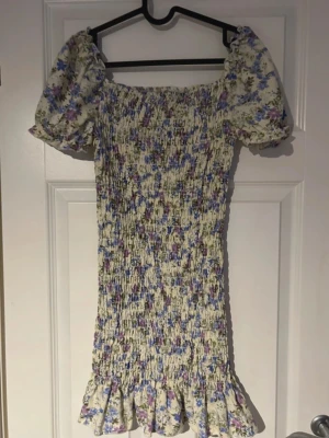 Sommar klänning - Supersöt kort klänning med blommigt mönster Smockad överdel som sitter bekvämt och formar sig fint, puffärmar, volangkant nertill för den där drömmiga, romantiska looken. Perfekt till sommarens alla tillfällen från picknick till fest 🌷(ifrån shein) 