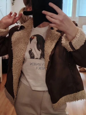 Brun teddyjacka med fårskinnsdetaljer🤎 - Säljer en brun teddyjacka med beige fuskpäls på krage, ärmslut och nederkant. Jackan har en cool bikerstil med dragkedja och är perfekt för sommar dagar. Passar dig som vill ha en mysig men trendig look😍