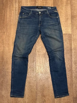 Mörkblå Jeans från Replay (Katewin) 31/32 - Snygga blå skinny jeans från Replay med klassisk femficksmodell och läderpatch bak. Jeansen har en tvättad look med subtila slitningar och kontrastsömmar. Tillverkade i stretchigt denim för skön passform. Perfekta till vardagslooken! Storlek 31/32. Snabb Leverans! 