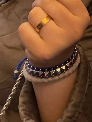 Blått armband med nitar och snören - Snyggt armband med blå snören och silverfärgade nitar. Armbandet har justerbar knytning och detaljer i grönt och vitt, vilket ger en cool och ungdomlig vibe. Perfekt accessoar för att lyfta din stil med lite extra färg.